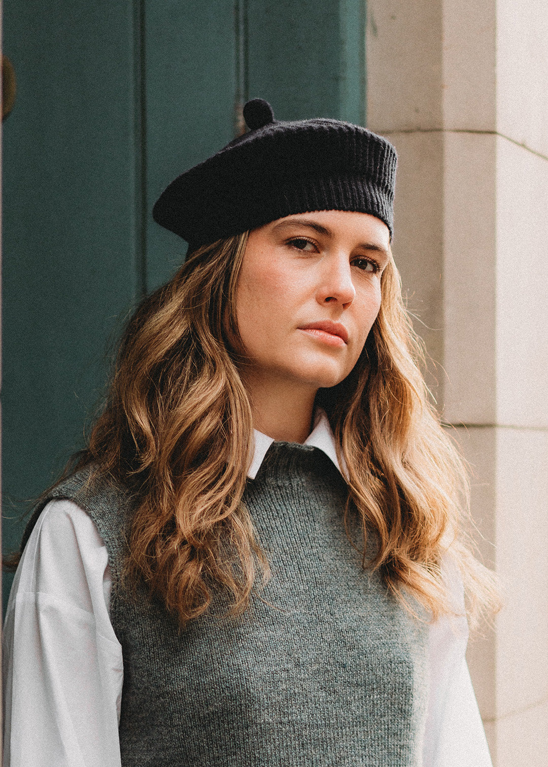 Navy lambswool knitted beret with a pom-pom.