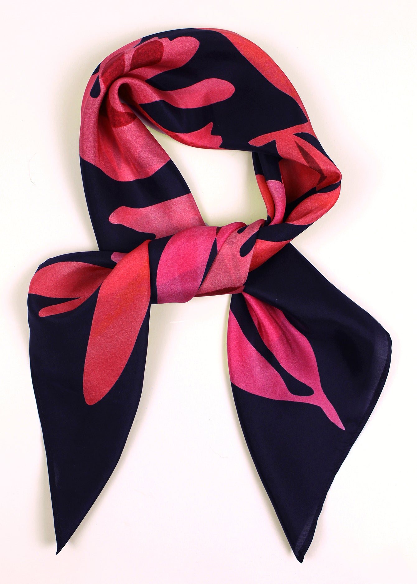 The Dulse silk scarf features a collaged print of dulse seaweed in vibrant pinks on a dark navy background.