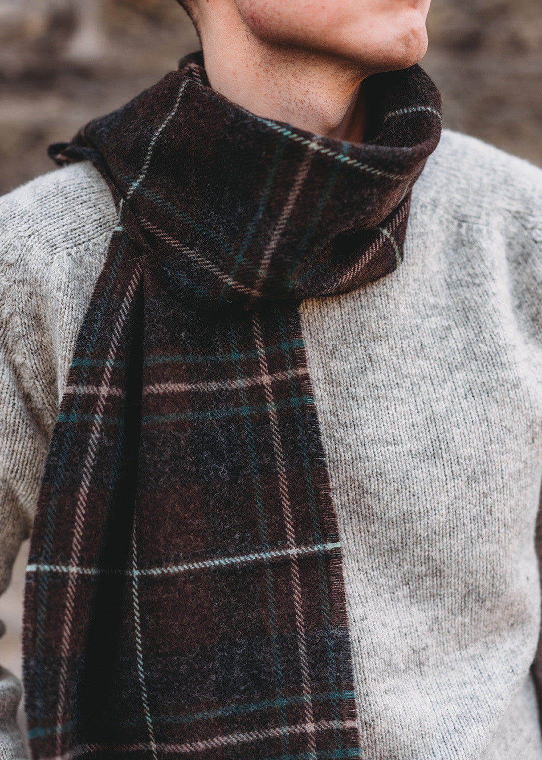 The Hebridean Glisk scarf is woven in soft, brushed lambswool with classic browns and greens.