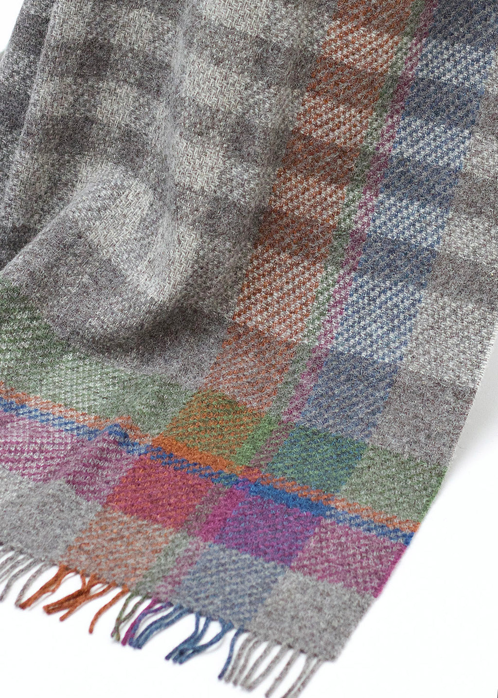 Rustic throw in un-dyed grey and cream Herdwick wool, with a colourful asymmetric check.