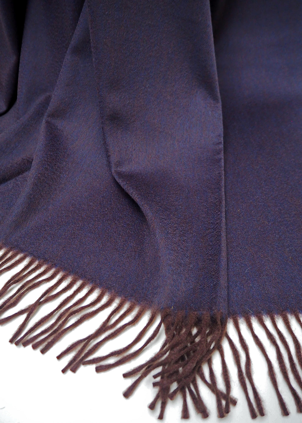 Luxurious cashmere throw woven in a striking blend of dark brown and aubergine.