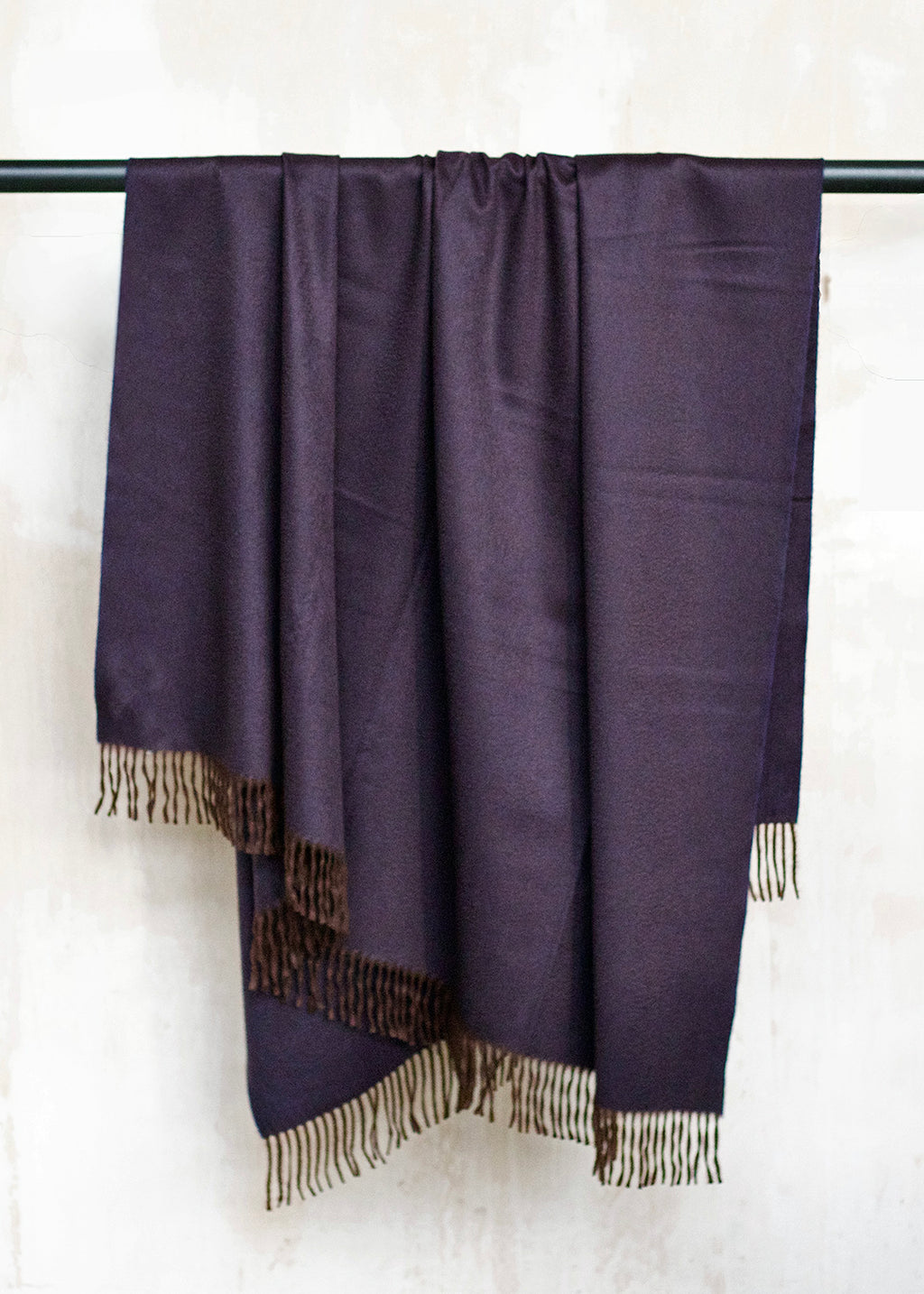 Luxurious cashmere throw woven in a striking blend of dark brown and aubergine.