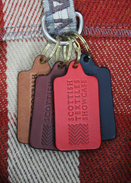 Handcrafted leather key ring in a range of colours, embossed with our Scottish Textiles Showcase logo.