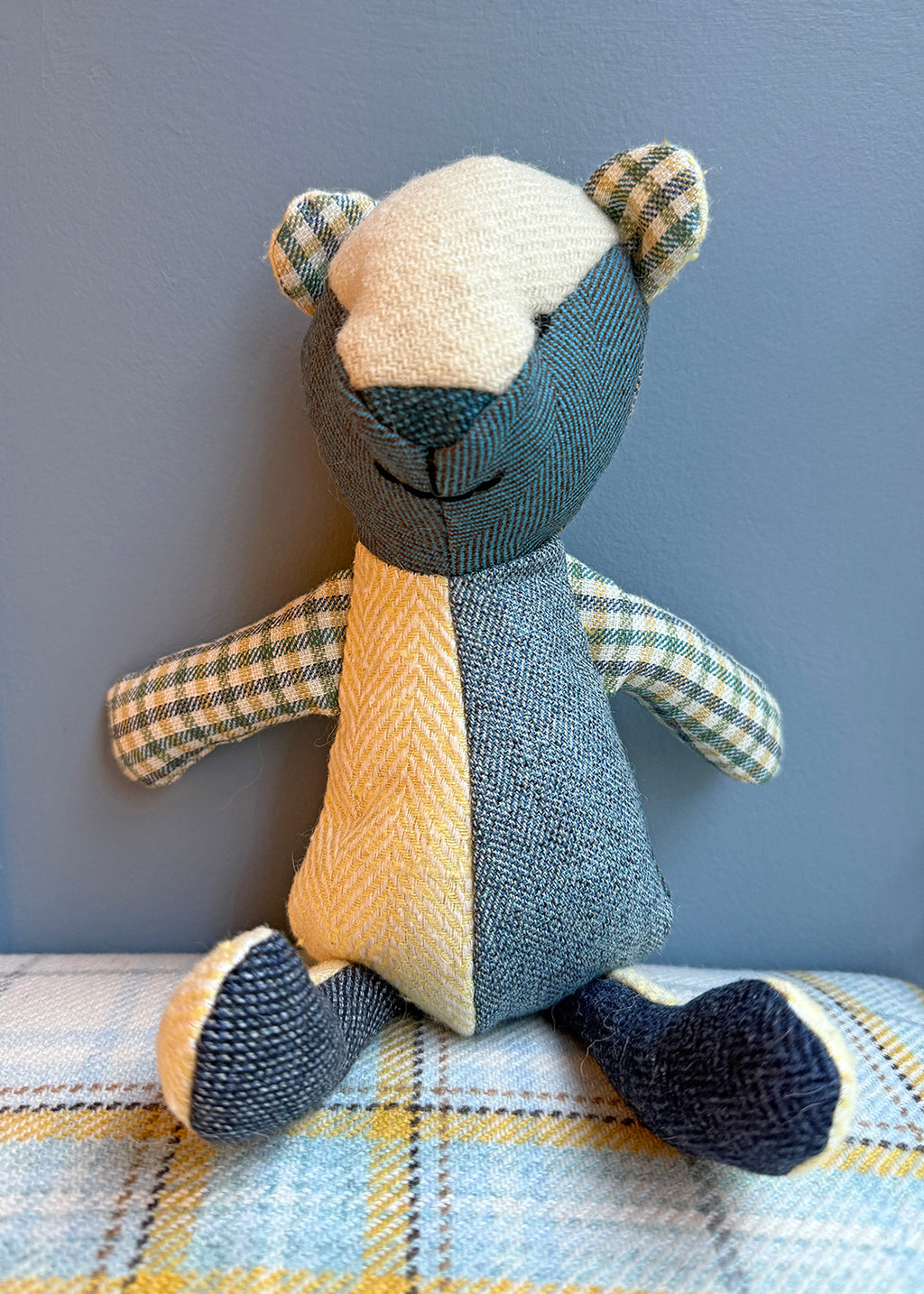 Unique patchwork tweed bear with different patterns and colours in shades of blue paired with natural tones.