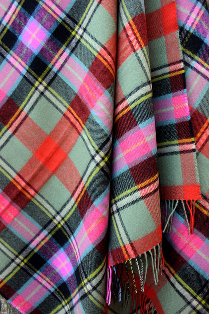 Lambswool tartan blanket woven in the vibrant greens, pinks and orange of the Bruce of Kinnaird tartan. Made in the Scottish Borders. Scottish Textiles Showcase.