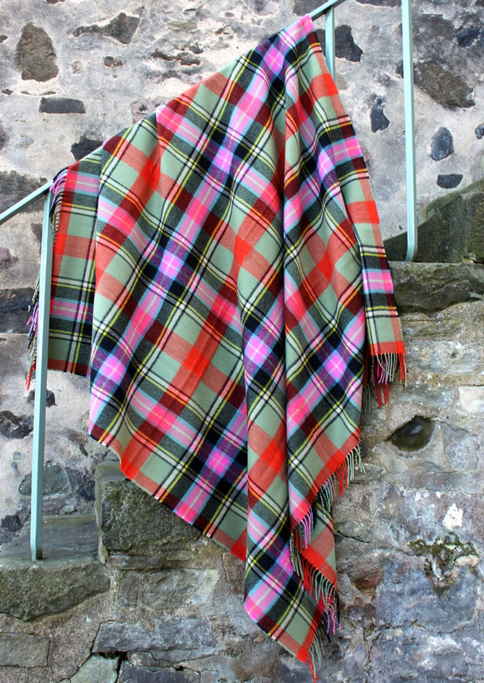 Lambswool tartan blanket woven in the vibrant greens, pinks and orange of the Bruce of Kinnaird tartan. Made in the Scottish Borders. Scottish Textiles Showcase.