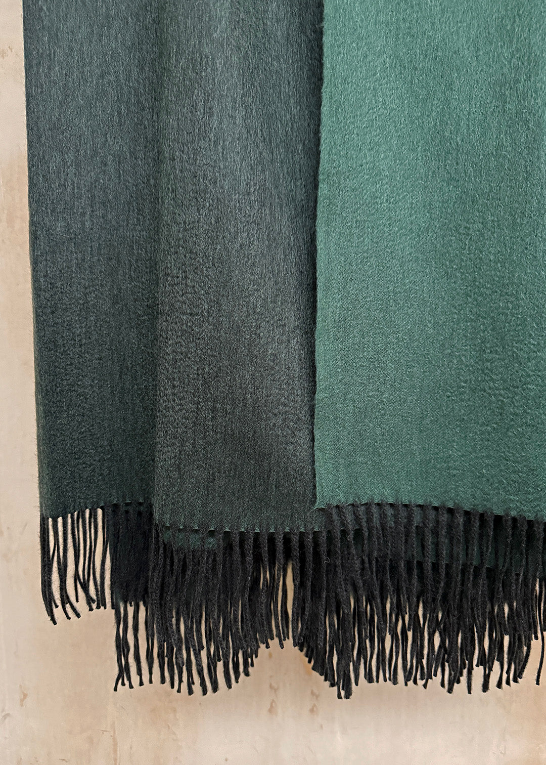 Luxurious cashmere throw woven in a striking blend of deep teal tones.