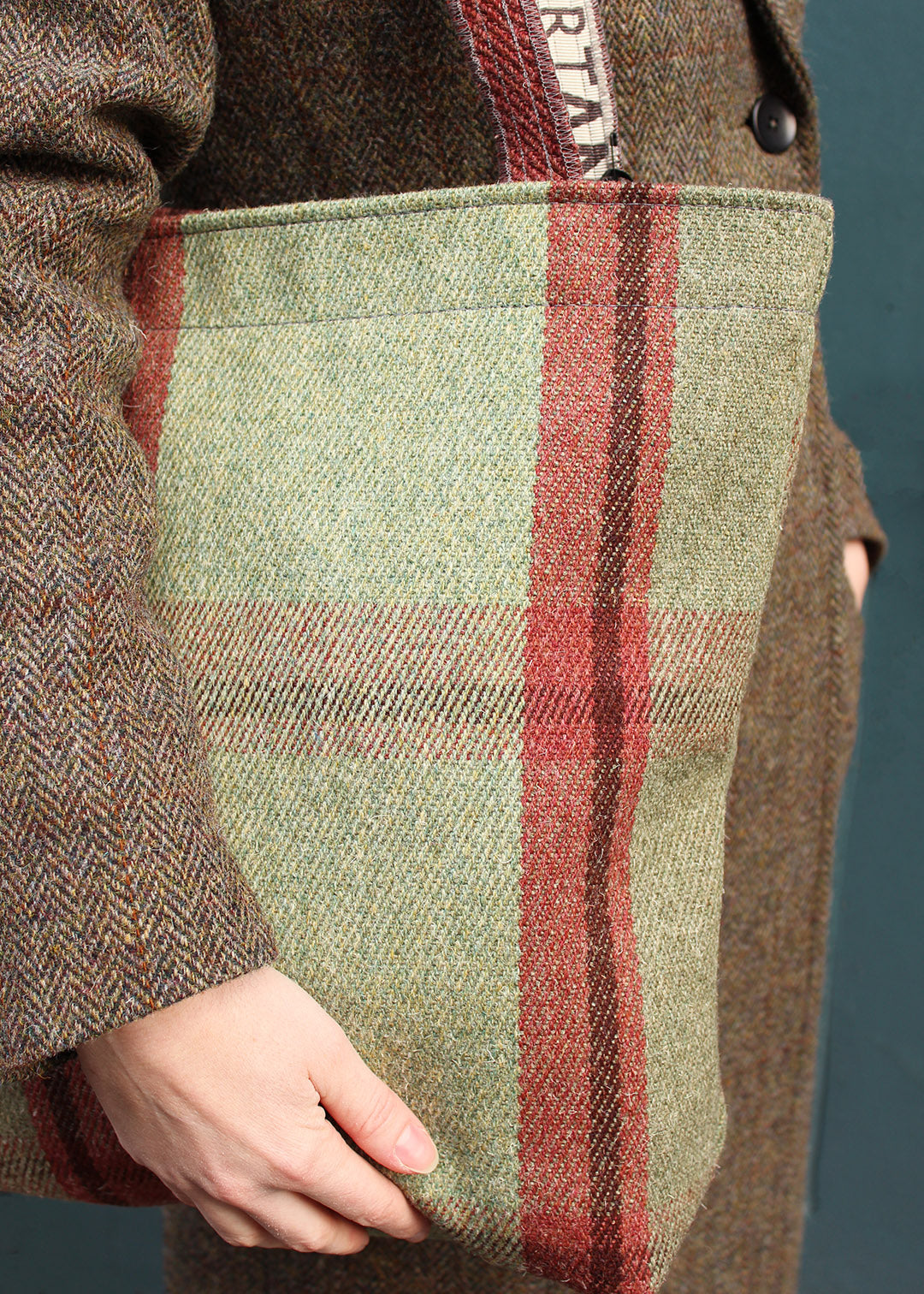 The Moniak bag is woven in an oversized check in sage green and rusty red.