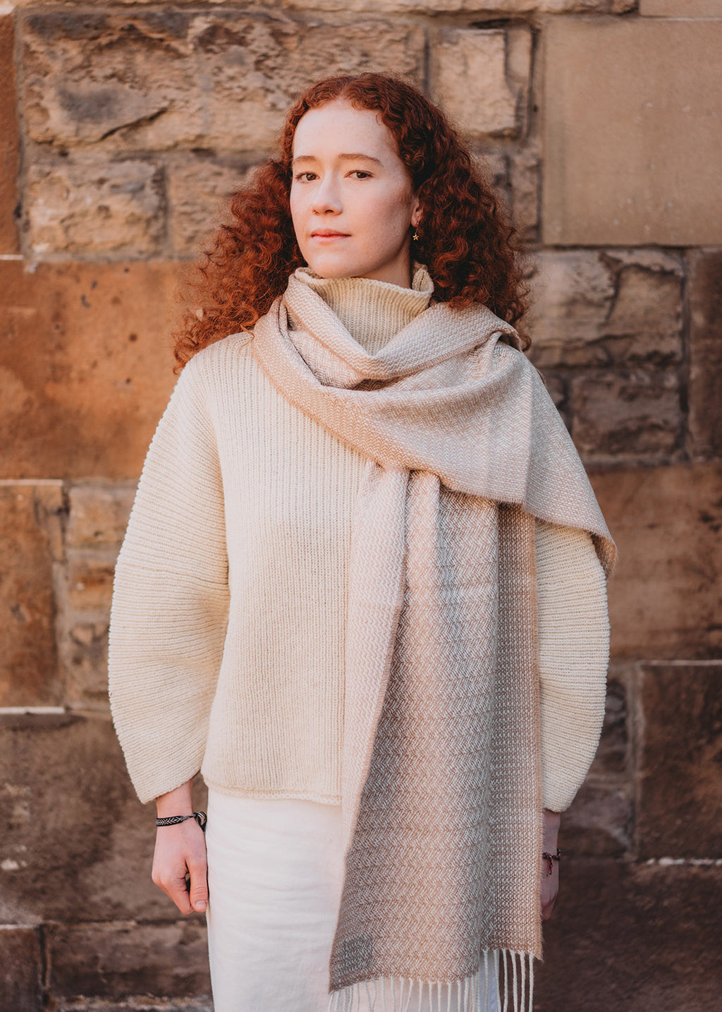 Alpaca scarf in caramel rippling barley shown on model.