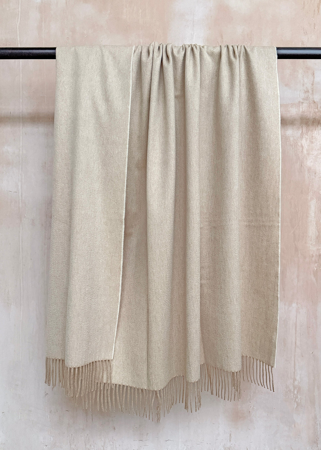 Luxurious cashmere throw woven in pale sand colour with a mother of pearl like sheen.