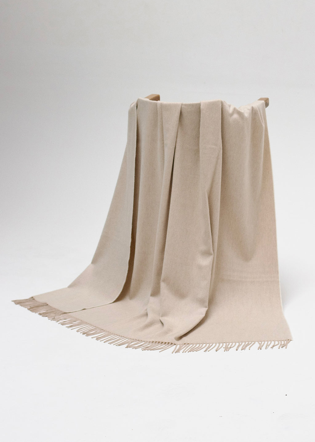 Luxurious cashmere throw woven in pale sand colour with a mother of pearl like sheen.