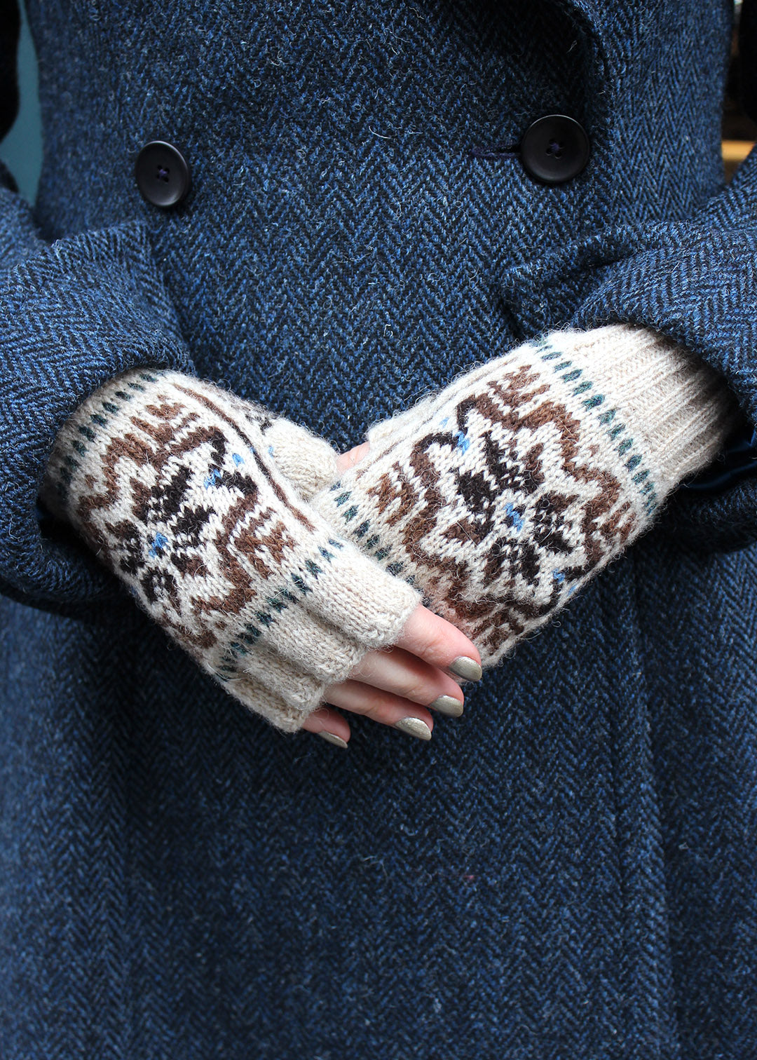 Hand knitted Fair Isle fingerless gloves in beige with contrasting details.