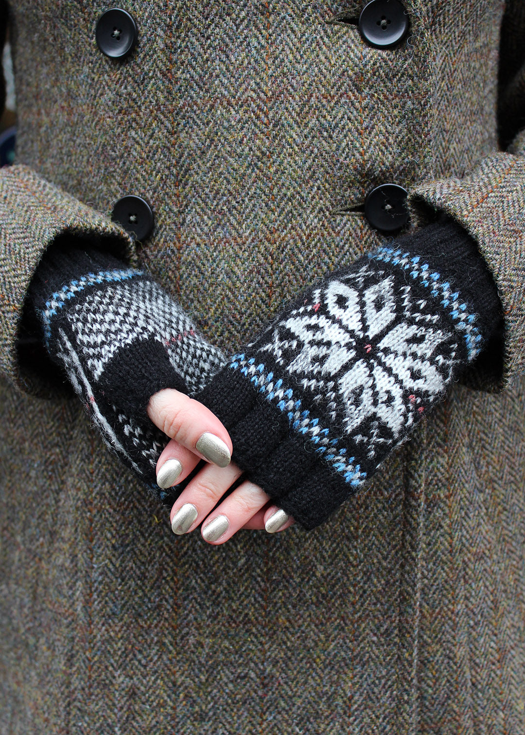 Hand knitted Fair Isle fingerless gloves in black with contrasting details.