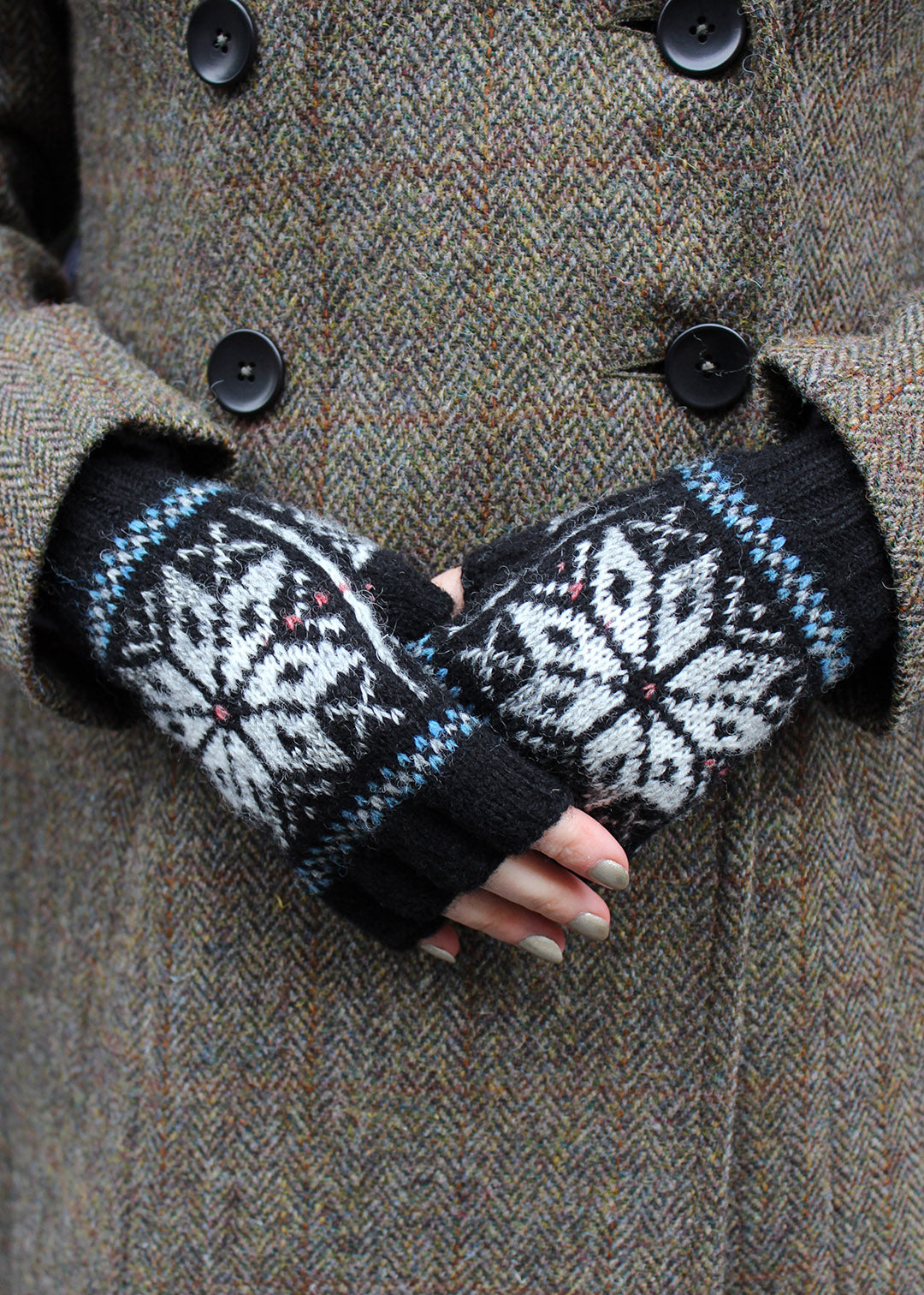 Hand knitted Fair Isle fingerless gloves in black with contrasting details.