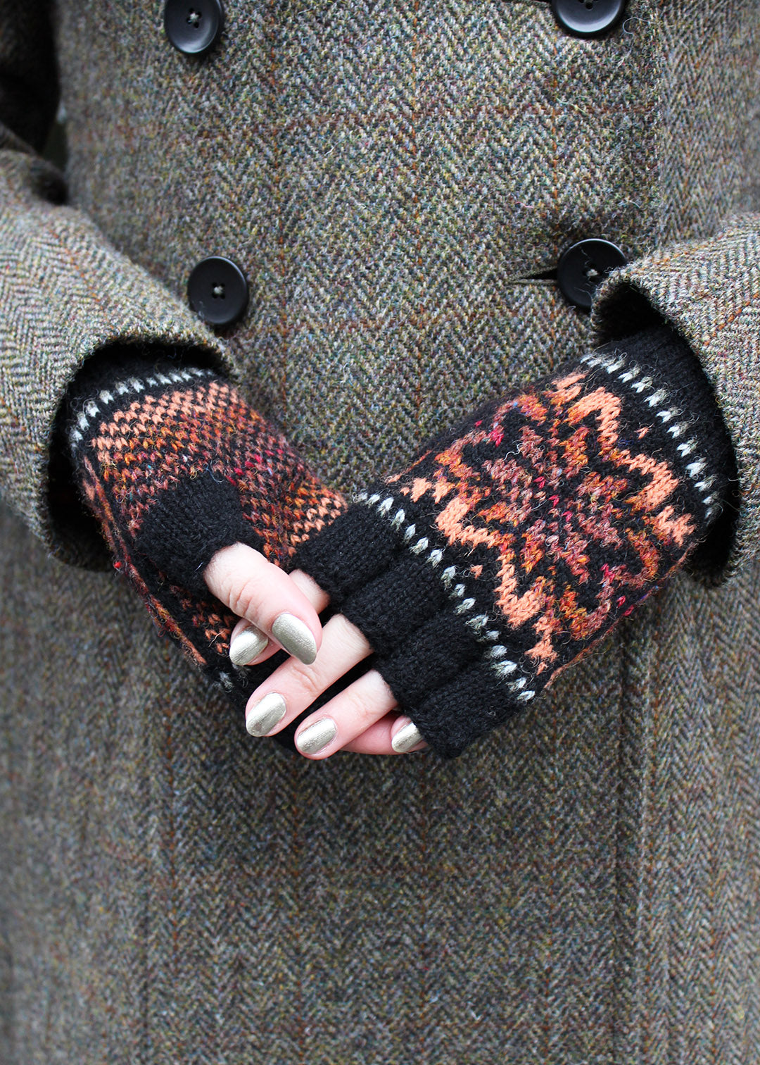 Hand knitted Fair Isle fingerless gloves in black with contrasting details.