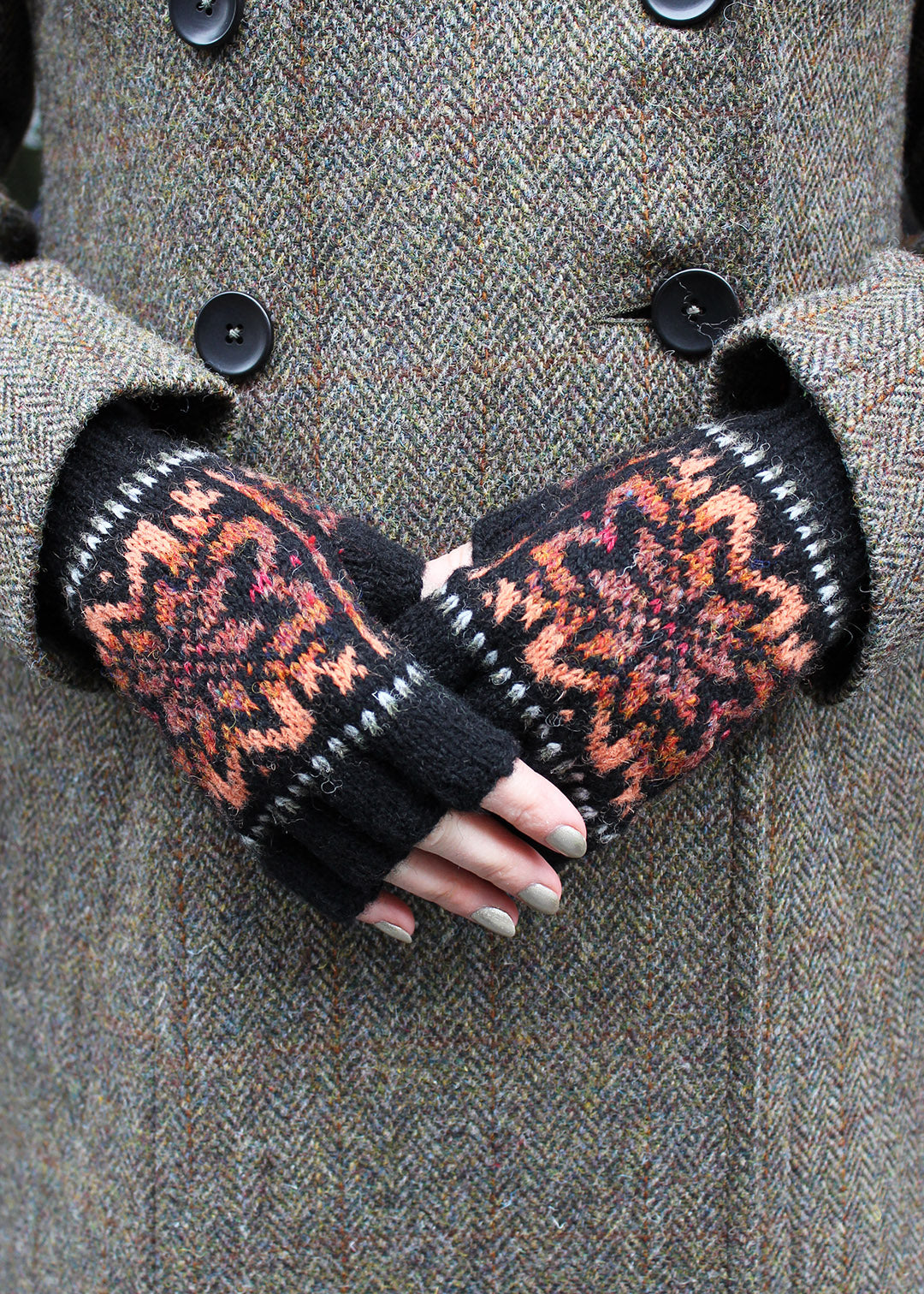 Hand knitted Fair Isle fingerless gloves in black with contrasting details.