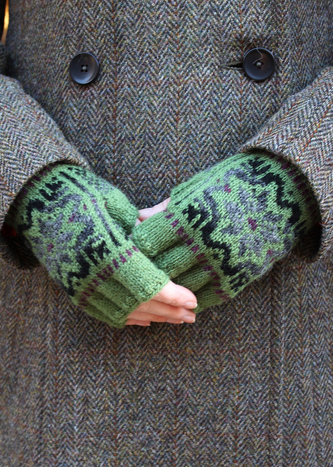 Hand knitted gloves in moss green with Fair Isle pattern.