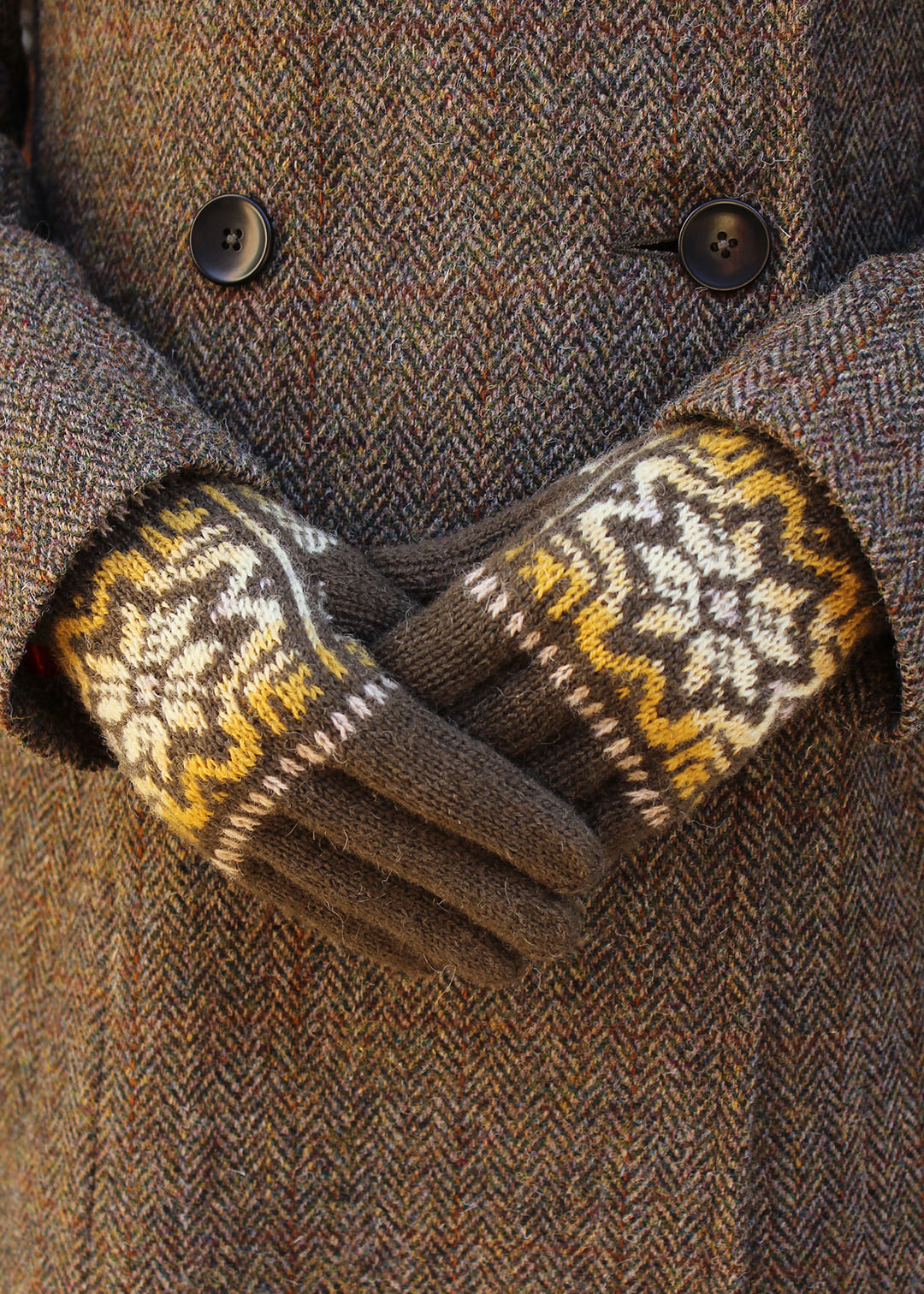 Hand knitted gloves in khaki green with Fair Isle pattern.