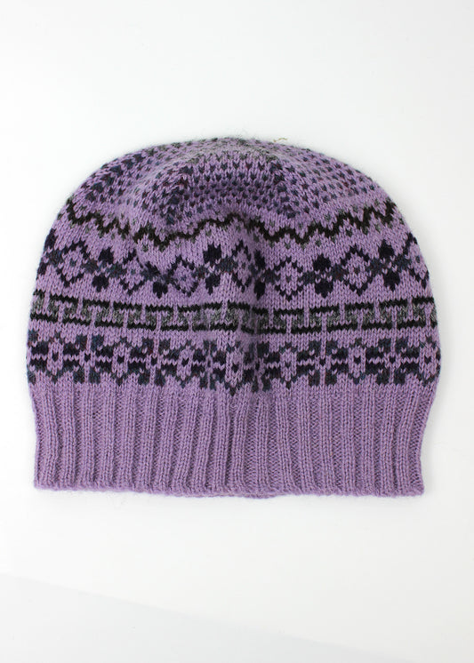 Hand knitted Fair Isle beanie hat in lilac with grey and dark purple details.