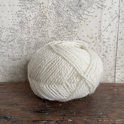 Ball of 4 ply finger weight cream white Bog Cotton yarn from Cheviot sheep in North Uist. Scottish Textiles Showcase.