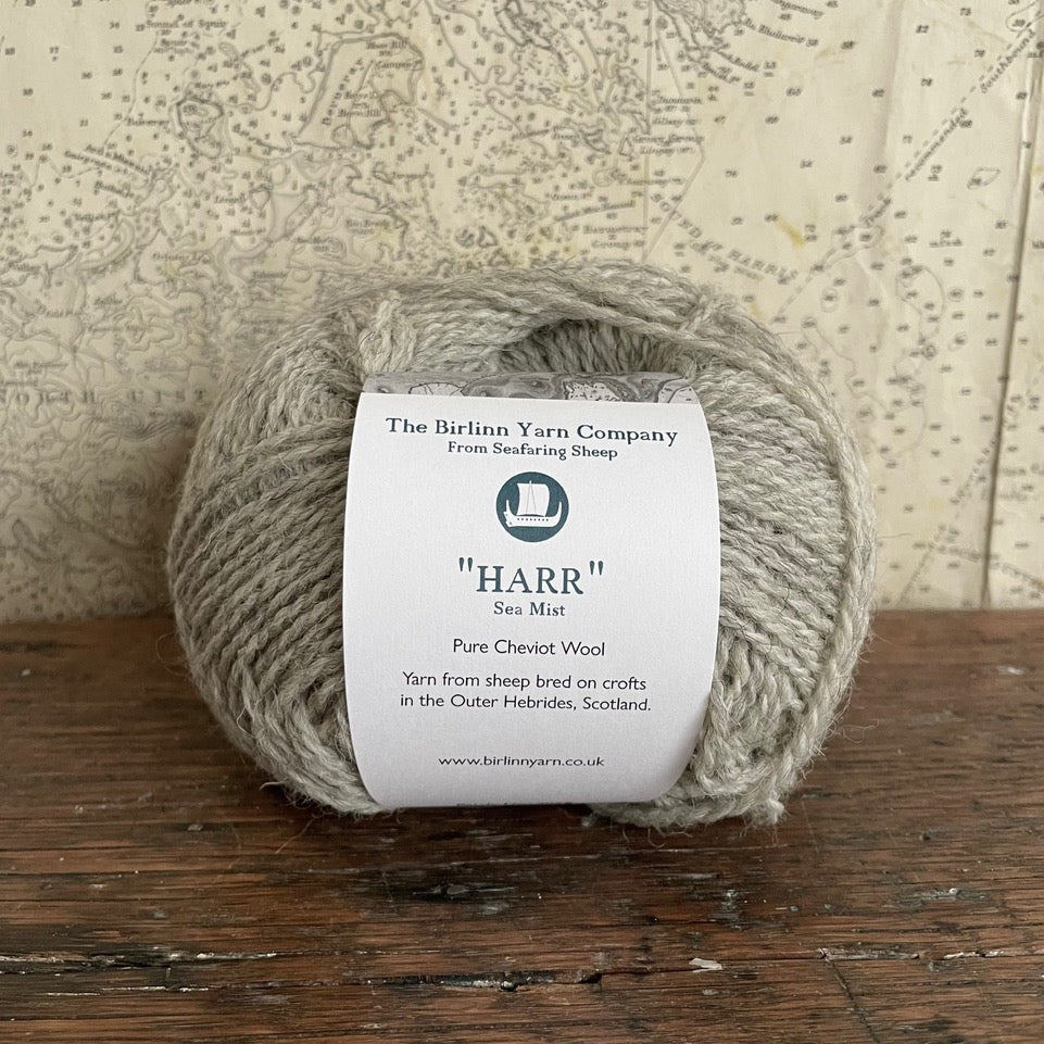 Ball of 4 ply finger weight light grey sea mist colour yarn from Cheviot sheep in North Uist and Hebridean sheep on Berneray. Scottish Textiles Showcase.