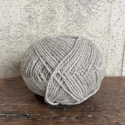 Ball of 4 ply finger weight light grey sea mist colour yarn from Cheviot sheep in North Uist and Hebridean sheep on Berneray. Scottish Textiles Showcase.