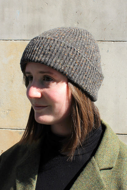 Knitted ribbed beanie hat in mushroom brown Donegal yarn with flecks of camel, rust and blue grey through it. Scottish Textiles Showcase.