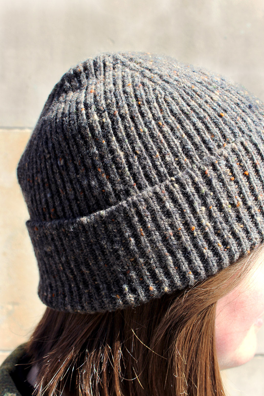 Knitted ribbed beanie hat in mushroom brown Donegal yarn with flecks of camel, rust and blue grey through it. Scottish Textiles Showcase.