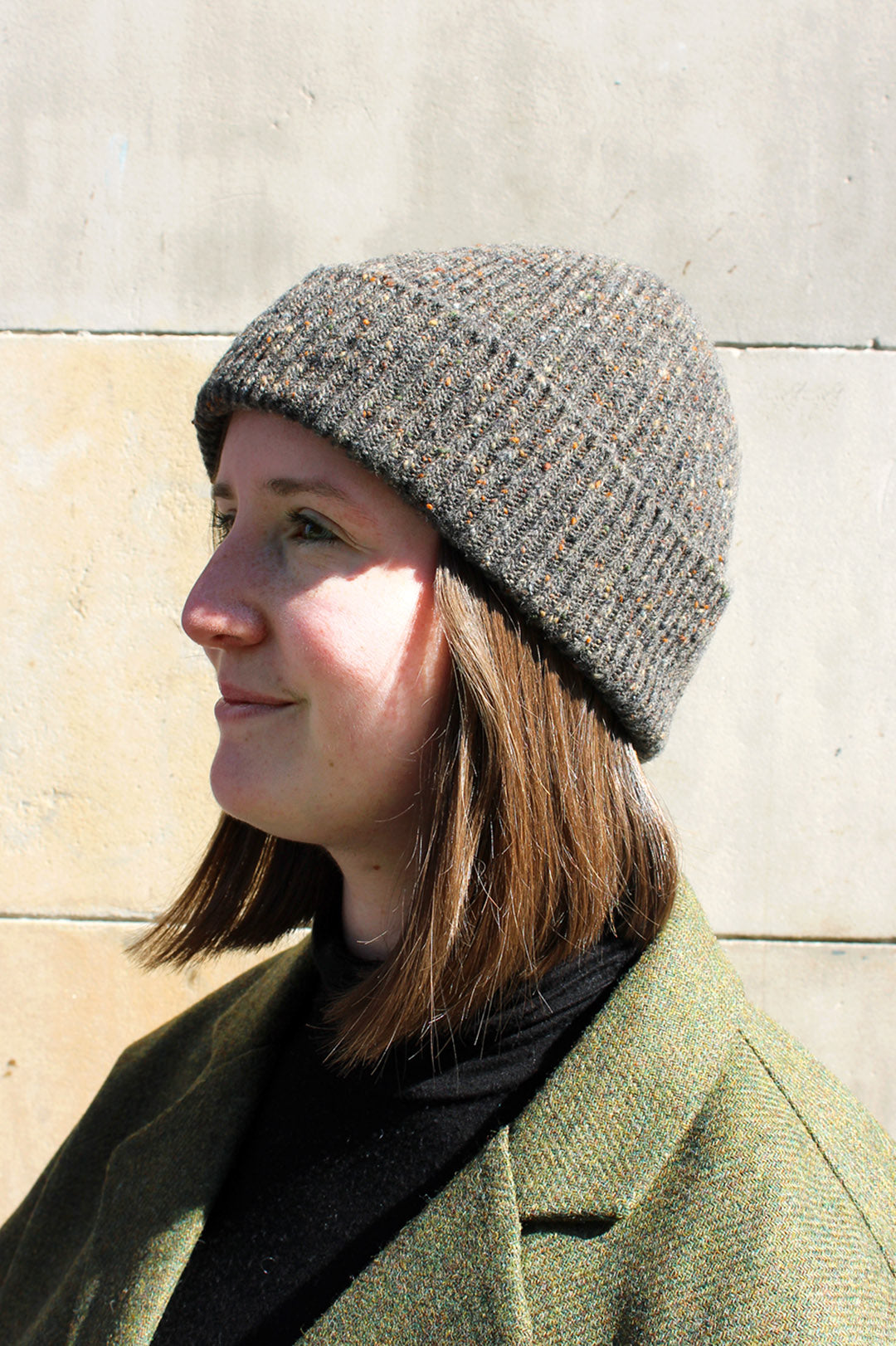 Knitted ribbed beanie hat in mushroom brown Donegal yarn with flecks of camel, rust and blue grey through it. Scottish Textiles Showcase.