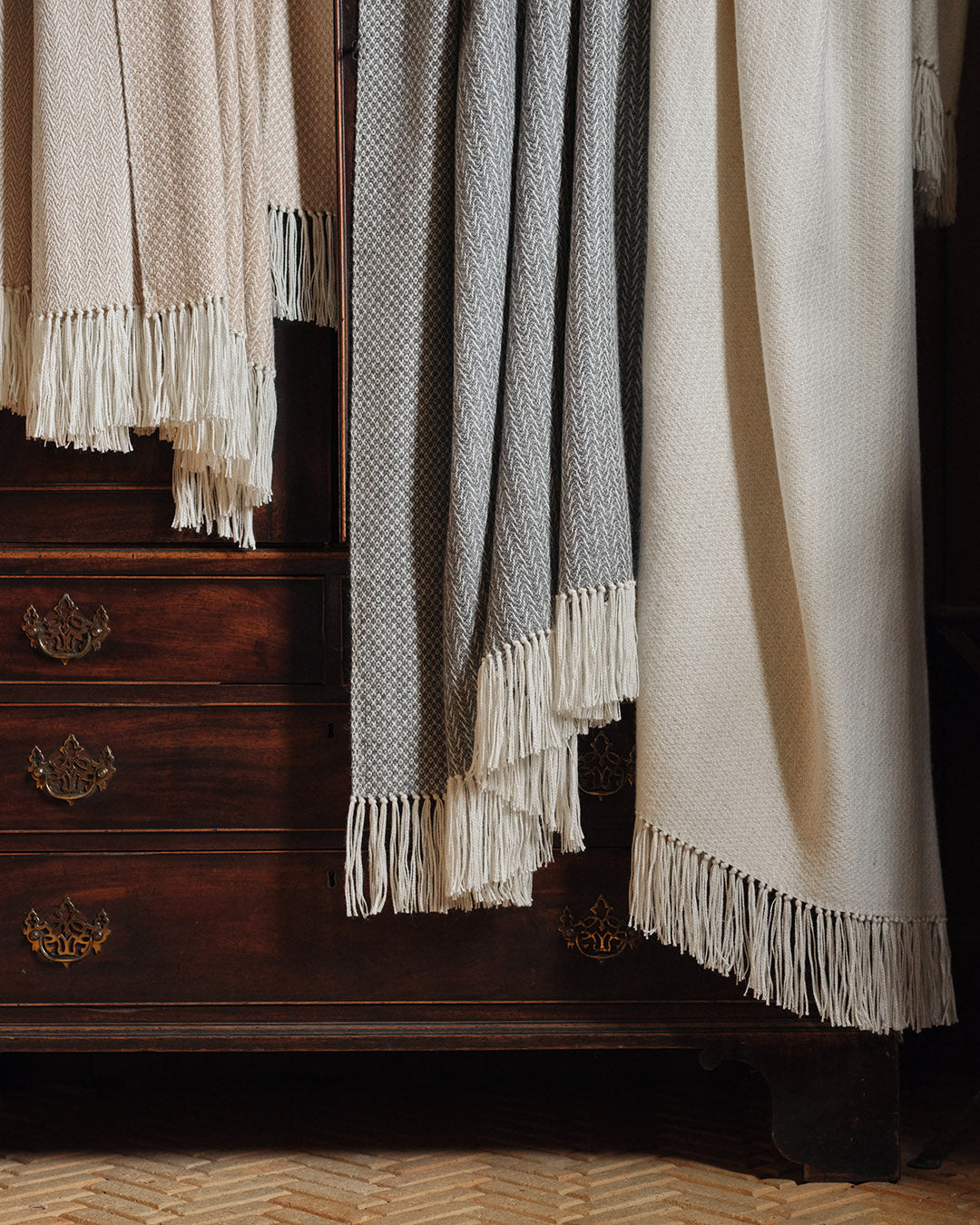 Araminta Campbell kingsize undyed alpaca throw collection in Woodland Inkcap pattern. Shown in rustic wooden interior.