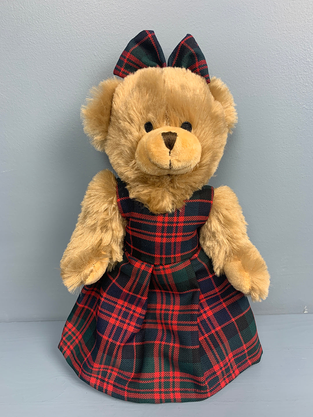 Teddy bear with tartan pinafore dress and tartan bow