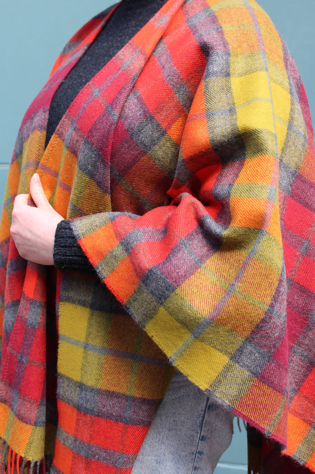 The Buchanan Berry tartan serape features a bold check in an eye catching combination of red, orange, chartreuse and grey.
