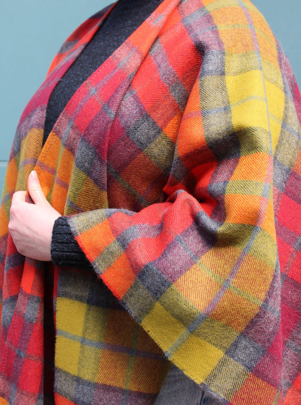 The Buchanan Berry tartan serape features a bold check in an eye catching combination of red, orange, chartreuse and grey.