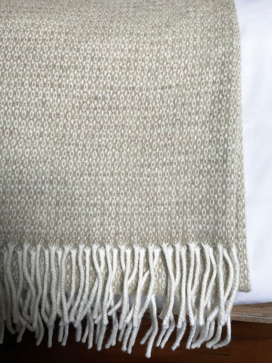 Generously sized pure merino lambswool throw woven in a delicate pattern in pale moss green and cream.