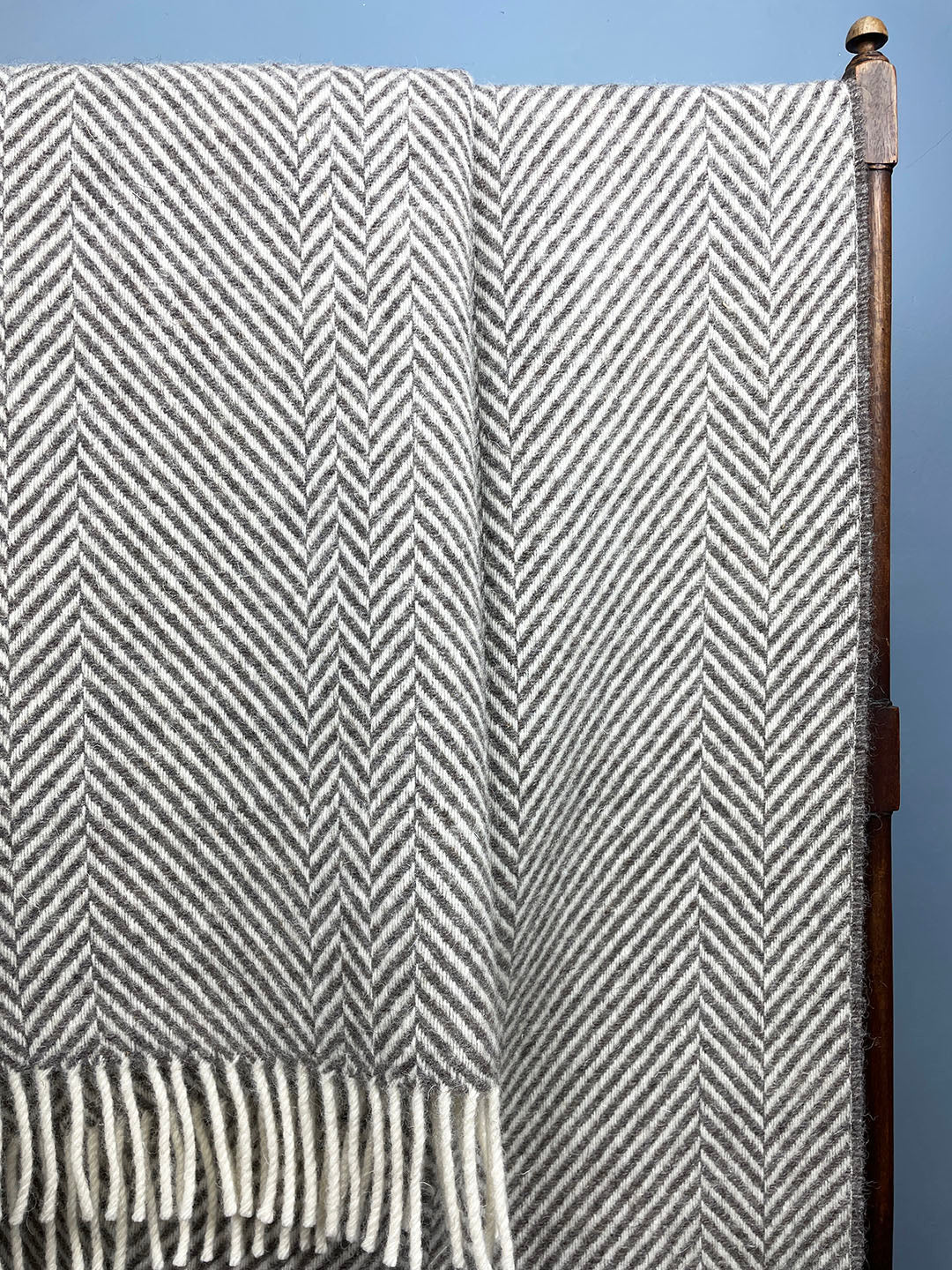 Grey blanket with tassels and geometric zig zag pattern 