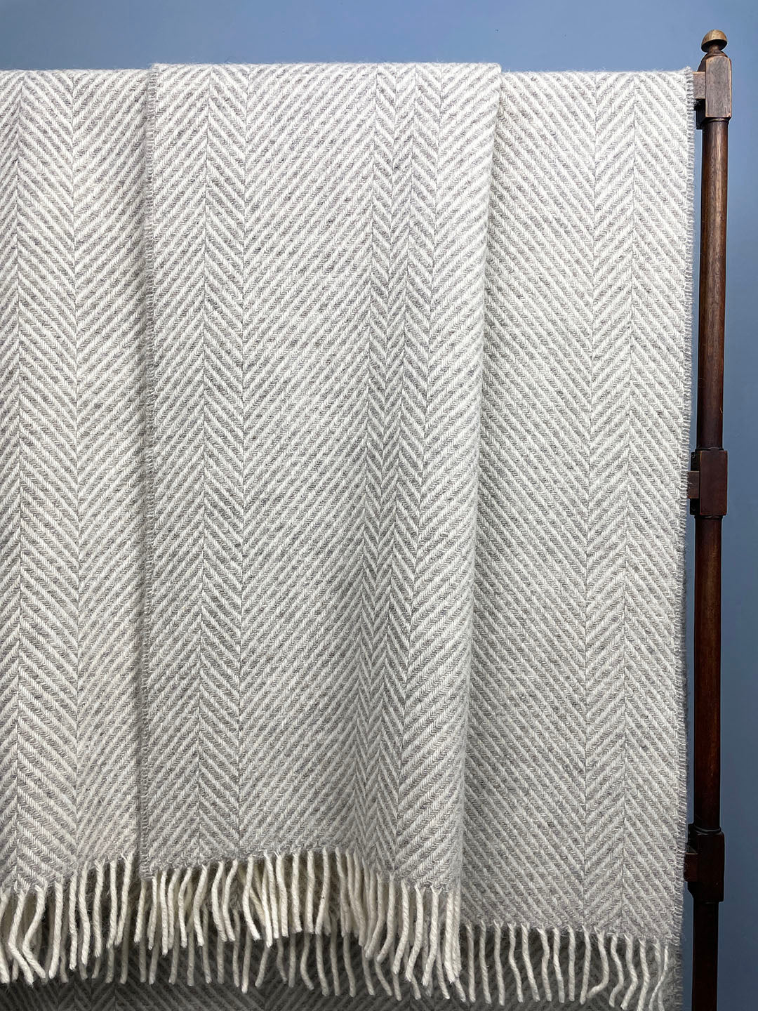 Silver grey blanket with tassels and geometric zig zag pattern