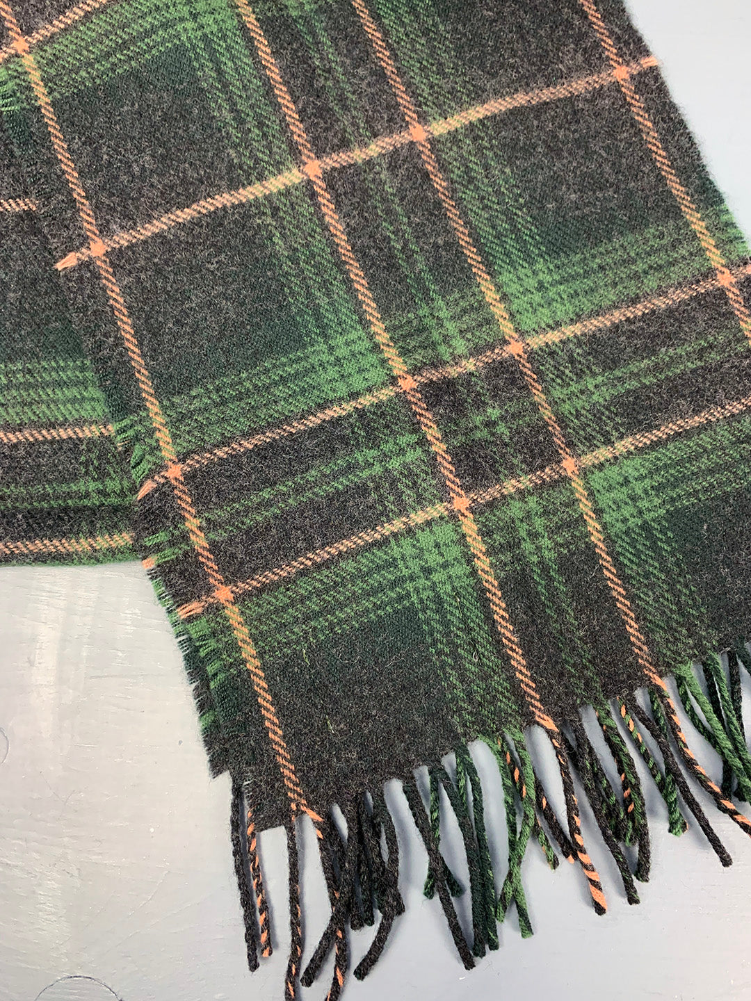 Scottish scarf woven in green tartan with light and dark green, with brown and orange throughout