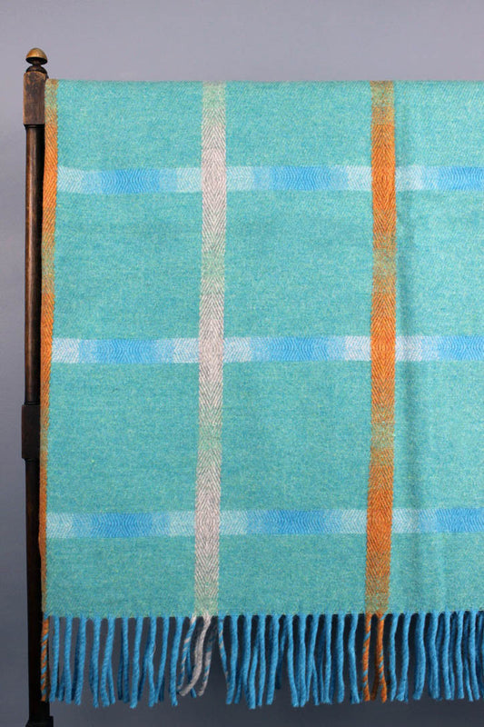 Maree throw woven in a contemporary check pattern with a turquoise base and vibrant orange overcheck. 
