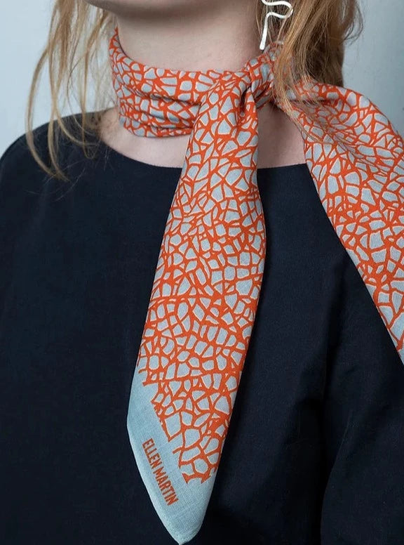 Wool and silk blend square scarf featuring intricate repeat pattern in pale blue and orange.