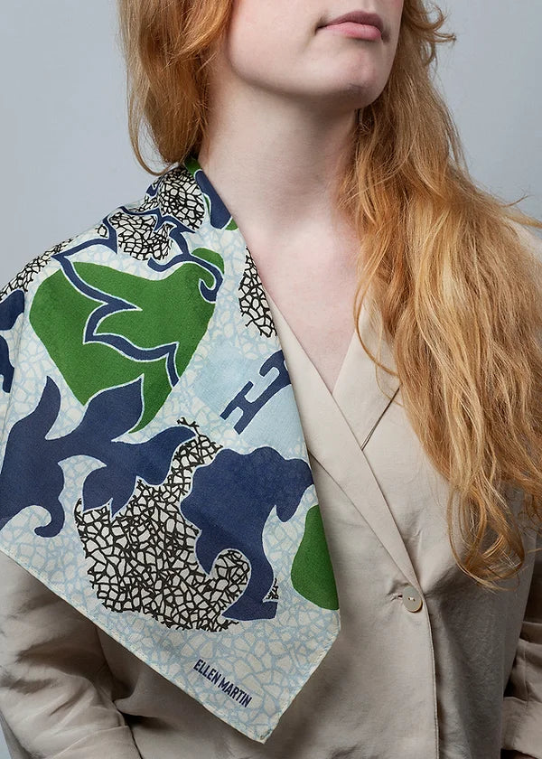 Wool and silk blend scarf digitally printed with a placement pattern in blue, green and black on an ivory background.