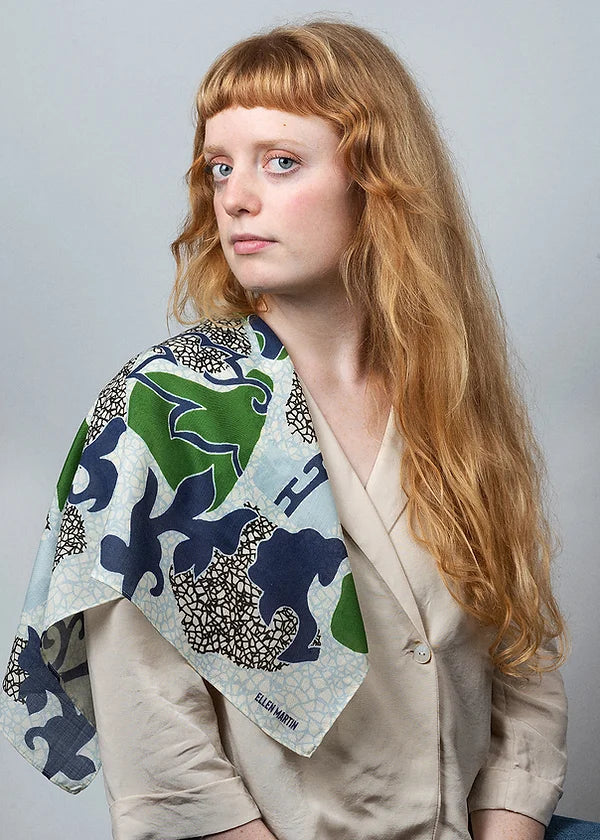 Wool and silk blend scarf digitally printed with a placement pattern in blue, green and black on an ivory background.